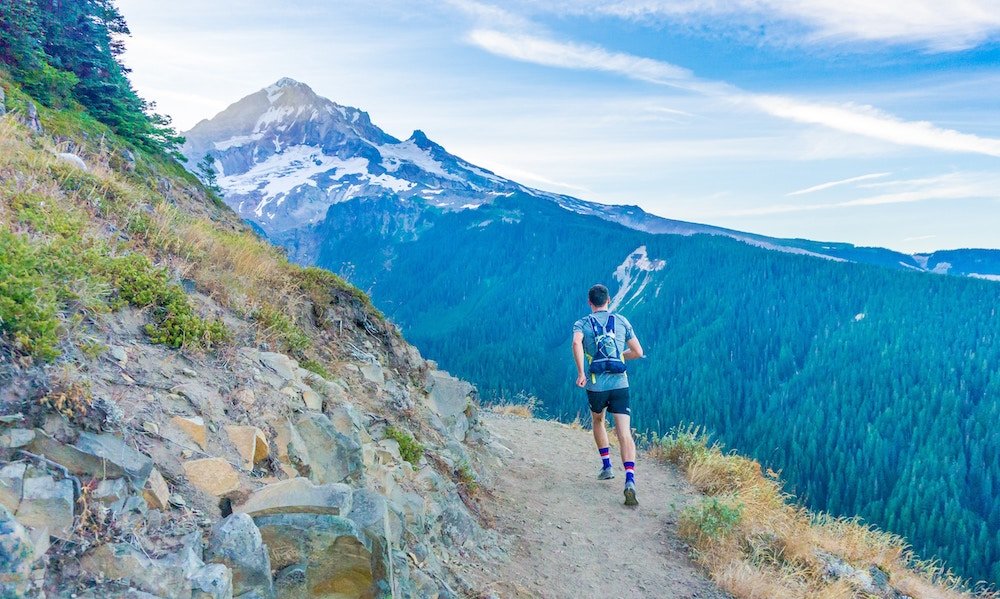 person running in the mountains with view