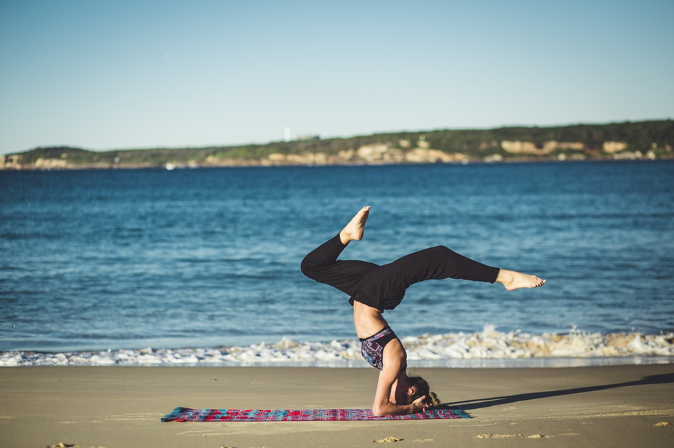 person doing yoga on beach